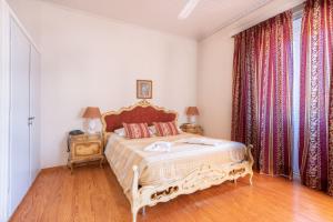 科孚镇Archontiko Petrettini Boutique Hotel的一间卧室配有床和带窗帘的窗户