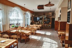 Dolní TošanoviceMotel Tošanovice的餐厅设有木桌和木椅