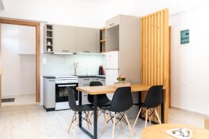 阿齐亚佩拉加Valentina's Apartments的厨房配有木桌和黑色椅子