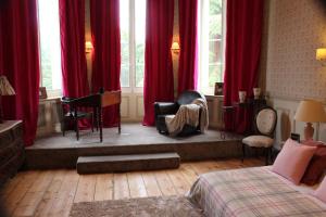 蒙桑木那城堡酒店的一间卧室配有红色窗帘、一张床和钢琴