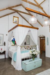 LangebaanwegSchaftplaas Cottages的一间卧室配有一张白色天蓬床