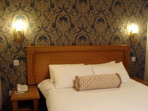 Cluain Eois克赖顿酒店 的卧室配有一张带两盏灯的墙壁床。