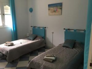 萨伊迪耶Perle d'Azur F3的客房内的两张床和毛巾