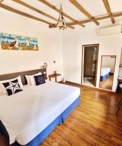 阿约拉港卡皮滩麦克斯住宿加早餐旅馆的卧室配有一张白色的大床,铺有木地板