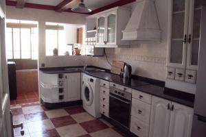 阿雷西费Reducto's Rooms的厨房配有白色橱柜、水槽和洗碗机。