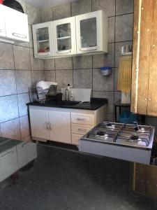 特里温福Chalé Triunfo的厨房配有炉灶和白色橱柜。