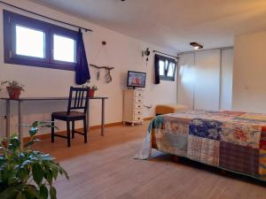 VenturadaOasis Sierra的一间卧室配有一张床、一把椅子和电视