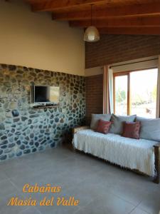 特来凡林Masia del Valle的客厅配有沙发和墙上的电视