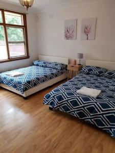 坎贝尔敦CAMPBELLTOWN HOLIDAY HOME 3 BED + FREE PARKING NCA039的一间卧室设有两张床,铺有木地板