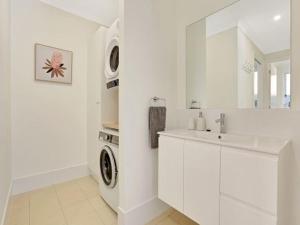 文森提亚Banksia on Blenheim by Experience Jervis Bay的白色的浴室设有水槽和洗衣机。