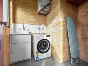 文森提亚Ammos by Experience Jervis Bay的洗衣房配有洗衣机和椅子