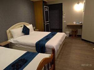花莲市冠伦饭店的酒店客房设有两张床和一张桌子。