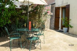圣埃尔布兰Manoir de L'Aisnerie的庭院里配有桌椅和遮阳伞