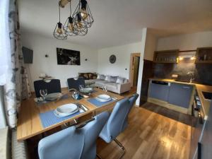 巴特霍夫加施泰因Appartement Wenger的一间带桌椅的用餐室和一间厨房