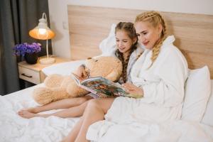 利沃夫Nota Bene Loft的两个女孩坐在床上看书