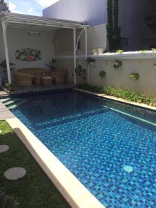 茂物Omah Kumpul Sentul的庭院里的一个蓝色海水游泳池