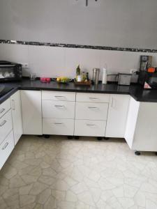 BobbauZu Hause auf Zeit bei Marion的厨房配有白色橱柜和黑色台面