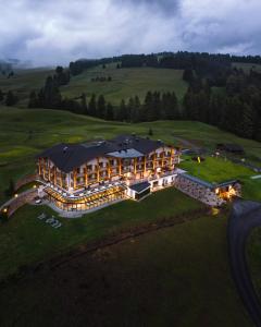 阿尔卑斯休斯山Brunelle Seiser Alm Lodge的山丘上一座大建筑的空中景观