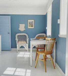 VejbystrandMagnarp Strandbad的蓝色的客房配有白色的桌子和椅子