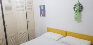 奥斯图尼洛萨马里纳公寓的一间卧室配有两张白色的床和黄色床头板