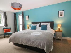 林顿Ferndale的一间卧室配有一张带蓝色墙壁的大床