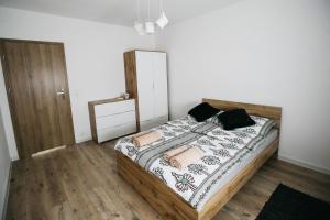 Zubrzyca DolnaApartamenty Perła Orawy的一间卧室配有一张带枕头的木床