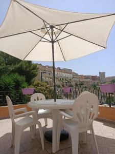 卡利亚里Casa dei Talenti的一张白色的桌子和椅子,配有雨伞