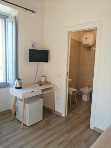 卡利亚里Casa dei Talenti的客房设有书桌、电视和浴室。
