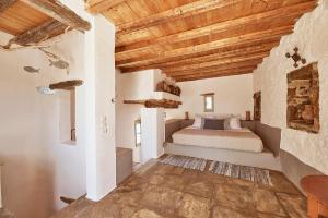 利瓦迪奥Nature Eco Living Serifos的一间带一张床的卧室,位于带木制天花板的房间内