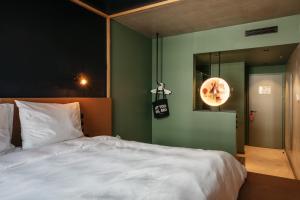 维也纳Superbude Wien Prater的卧室配有白色的床和绿色的墙壁