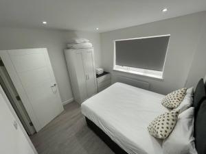 达格纳姆London Dagenham Apartments的一间小卧室,配有一张床和电视