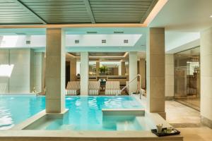 斯沃伦塔Electra Kefalonia Hotel & Spa的酒店大堂的大型游泳池,设有柱子
