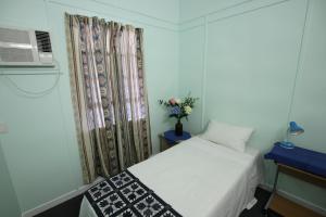 Cairns NorthCairns Sunshine Lodge的一间小卧室,配有白色的床和窗户