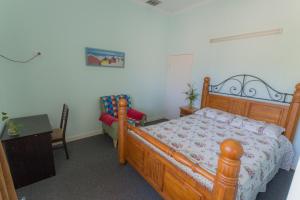 Cairns NorthCairns Sunshine Lodge的一间卧室配有一张木床和一张桌子