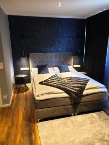 阿恩多夫Hotel Kornblume的一间卧室配有一张大床和蓝色床头板