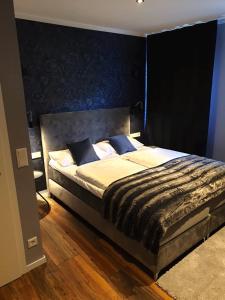 阿恩多夫Hotel Kornblume的一间卧室配有一张大床和黑色床头板