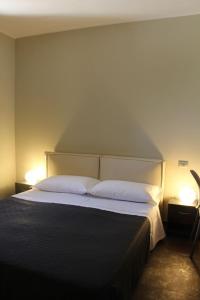 焦维纳佐Hotel Torre Domini的一间卧室配有一张大床和两盏灯
