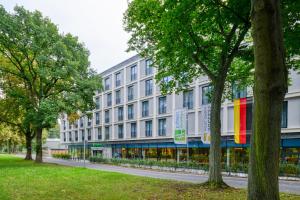 哥廷根Holiday Inn Express - Goettingen, an IHG Hotel的一座白色的大建筑,上面有五颜六色的旗帜