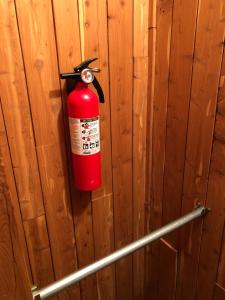 LewisvilleNewhouse Family Inn的挂在木墙上的红色消防栓