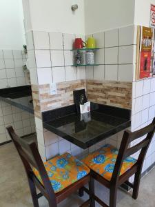 库亚巴Suite 03 - Independente, privativa e aconchegante的厨房配有两把椅子和带台面的台面