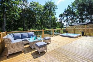 约克Hollicarrs - Kingfisher Lodge的平台上设有带沙发和桌子的庭院