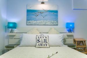 曼加利亚维拉卡萨菲娜服务式公寓的一间卧室,卧室里配有一张床,鸟儿飞翔在空中