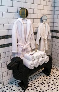 曼加利亚维拉卡萨菲娜服务式公寓的浴室设有狗雕像、毛巾和浴袍