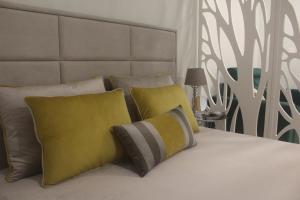普拉亚达维多利亚Praia Horizonte Studio's - RRAL nº3195的一张配有黄色和灰色枕头的床