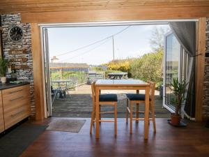 科特布里奇Blackbrae Cabin的一个带桌椅的厨房和一个阳台