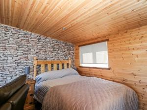 科特布里奇Blackbrae Cabin的一间卧室设有一张床和砖墙