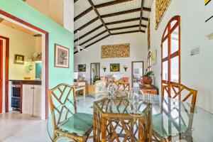 GingerlandNevis Home with Pool, Stunning Jungle and Ocean Views!的用餐室以及带玻璃桌和椅子的厨房