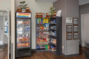 里贾纳Home Inn & Suites Regina Airport的冰箱和装满食物和饮料的书架