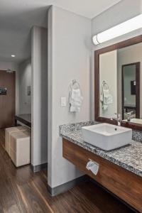 里贾纳Home Inn & Suites Regina Airport的一间带水槽和镜子的浴室