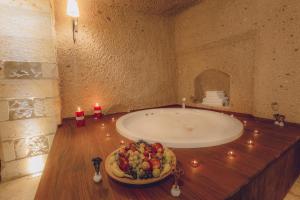 乌奇希萨尔Vasıl Cave Hotel的一间带一碗水果和浴缸的浴室